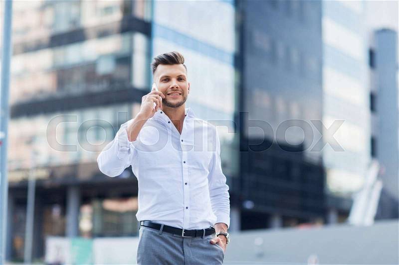 Technology, communication and people concept - happy man with smartphone calling on city street, stock photo
