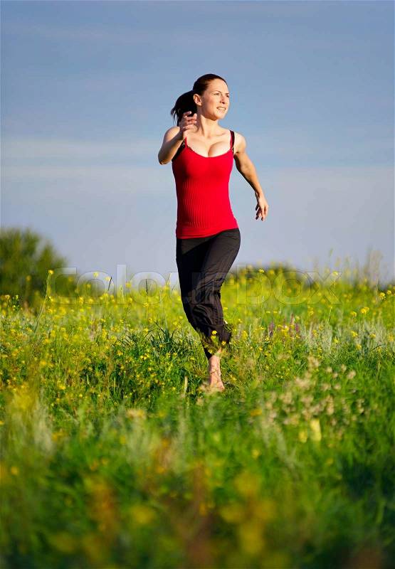 Sport woman running on a sunset field, stock photo