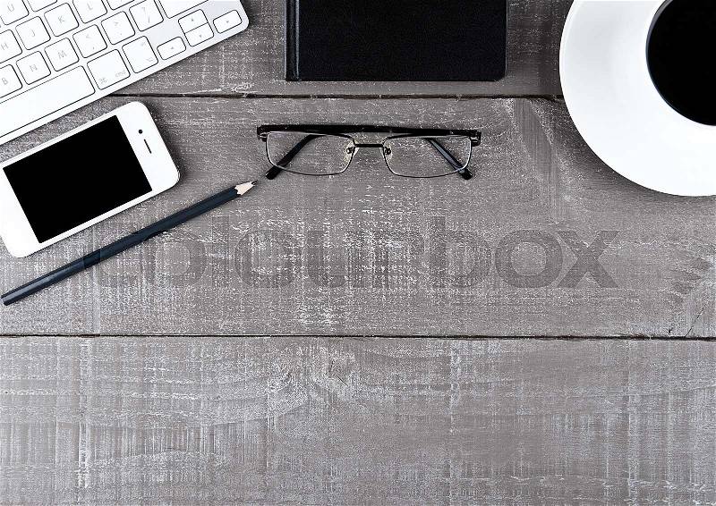 Keyboard with phone notebook and glasses on office desk, stock photo