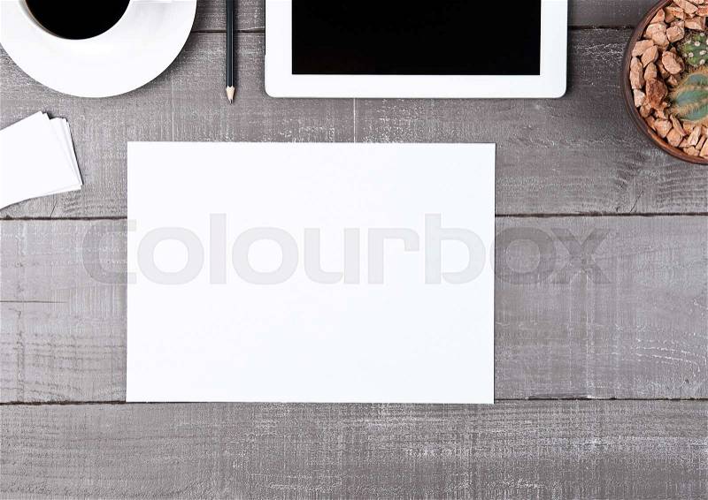 Graphic tablet with cactus paper sheet and coffee on office desk, stock photo