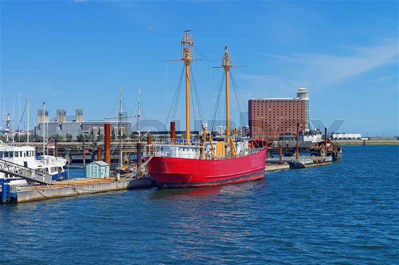 Red ship moored in the port in Boston, the United States. The Port of Boston is the major seaport in Massachusetts. Historically, it was an entry point for many immigrants, stock photo