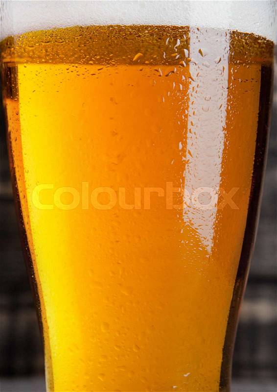 Glass of beer with frost on wooden background, stock photo
