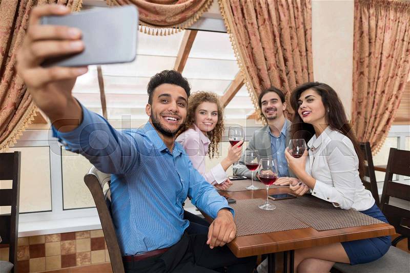 Young Business People Group Sitting At Cafe Make Selfie Photo On Smart Phone Drink Wine Friends Communication Event Celebration, stock photo