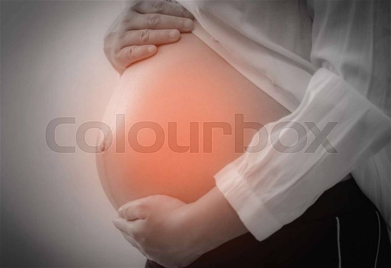 Pregnant woman having abdominal pain in belly, stock photo