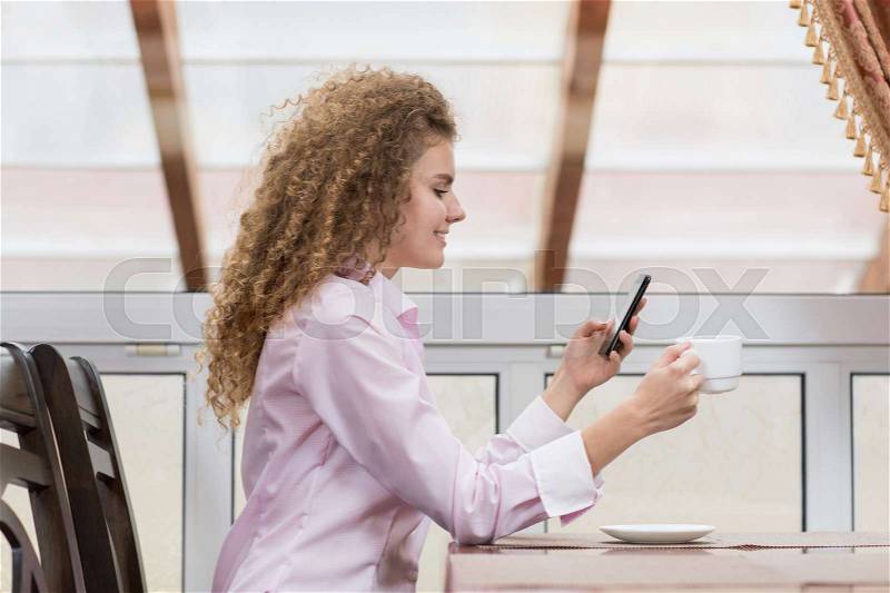 Business Woman Chatting Cell Phone Messaging Hold Coffee Cup, Happy Smiling Young Beautiful Girl Sit On Table Break Restaurant Interior, stock photo