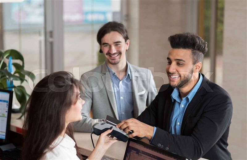 Young Business Man On Hotel Reception Office, Businessman Check In Using Cell Smart Phone Woman Desk Meeting Stuff, stock photo