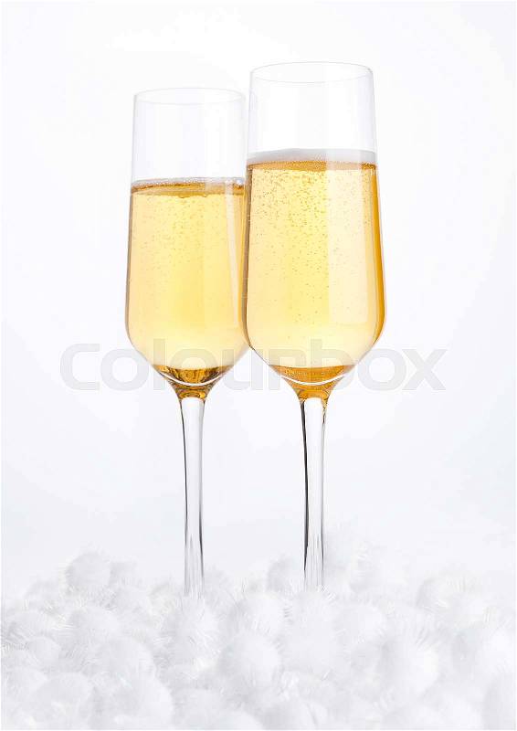 Glasses of champagne with bubbles on snow on white background, stock photo
