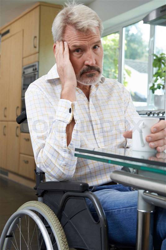Depressed Man Sitting In Wheelchair At Home, stock photo