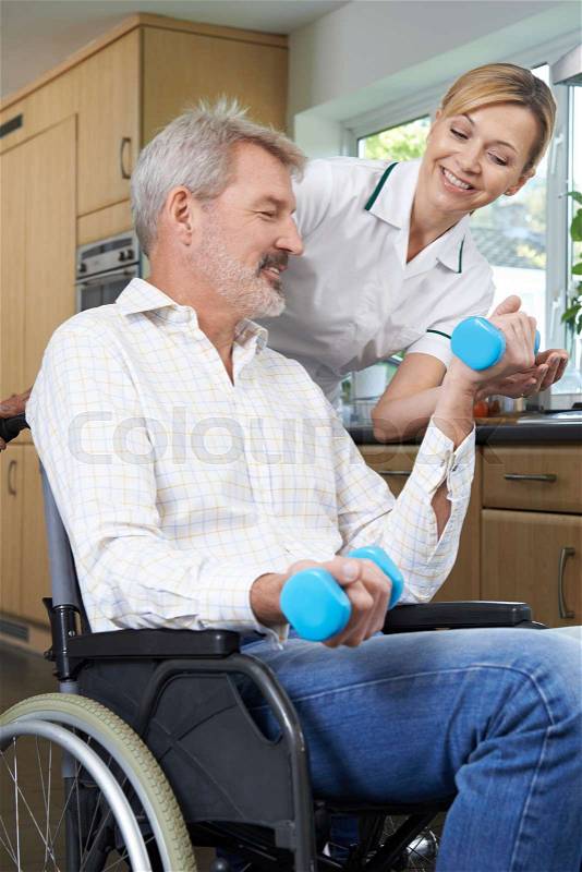 Physiotherapist Helping Man In Wheelchair With Exercises, stock photo