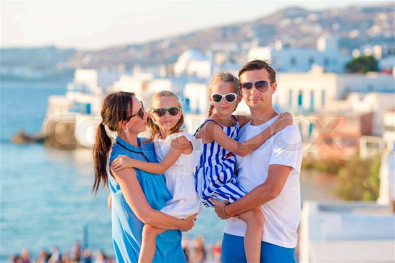 Family in Europe. Parents and kids on Little Venice background on Mykonos Island, in Greece, stock photo