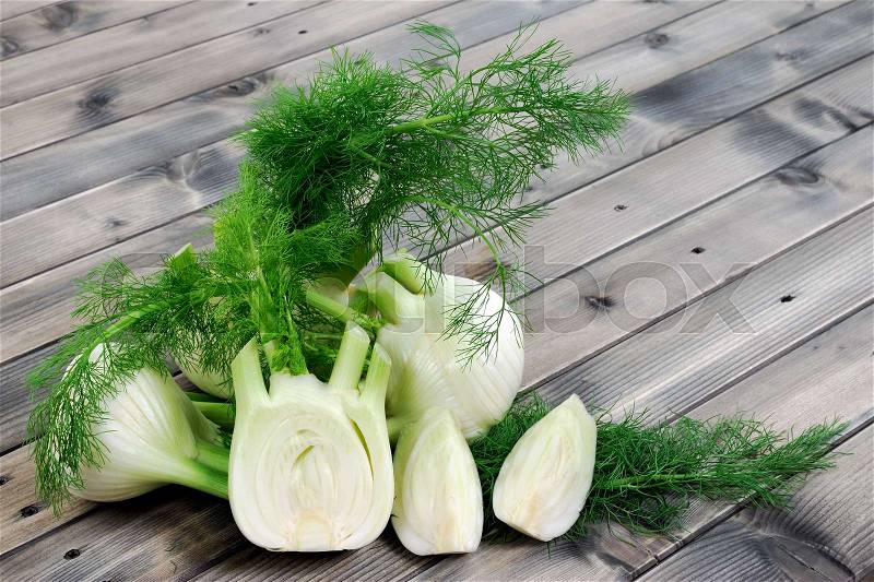 Fresh fennel cut just harvested, photographed on wooden table, stock photo