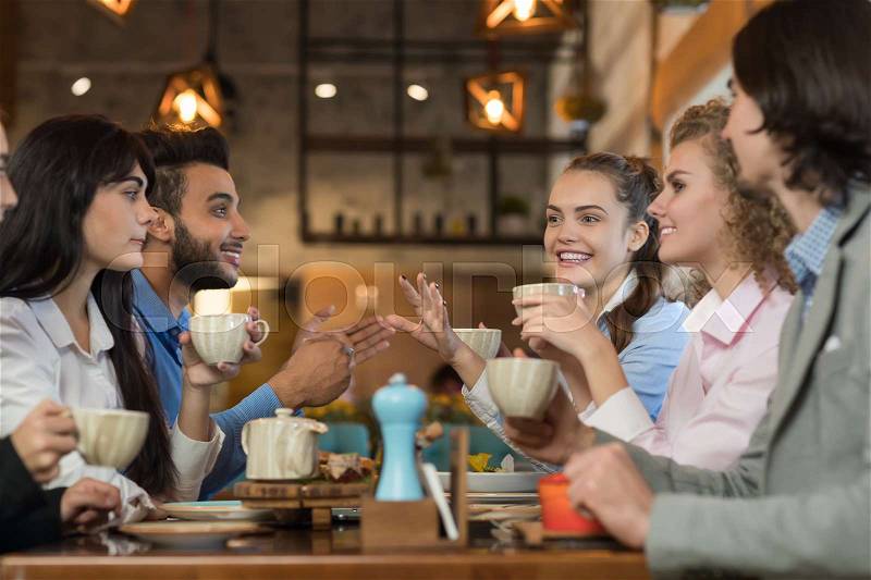 Young Business People Group Drink Coffee Sitting Cafe Table, Friends Hold Cup Smiling Mix Race Men Women Talking, stock photo