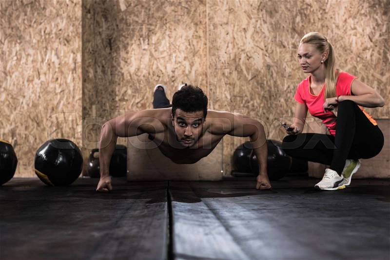Sport Fitness People Crossfit Training, Young Healthy Hispanic Man Do Push Ups Woman Trainer Gym Interior, stock photo