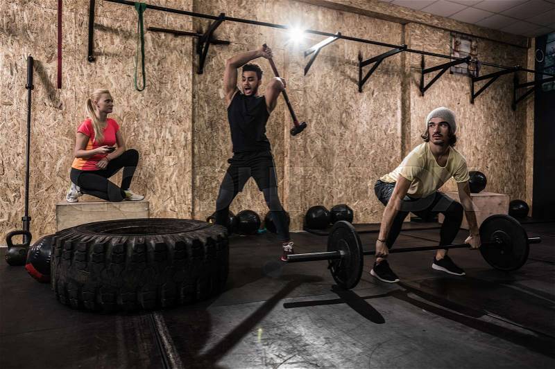 Sport Fitness People Group Crossfit Training Equipment, Serious Young Healthy Man And Woman Gym Interior Doing Exercises, stock photo