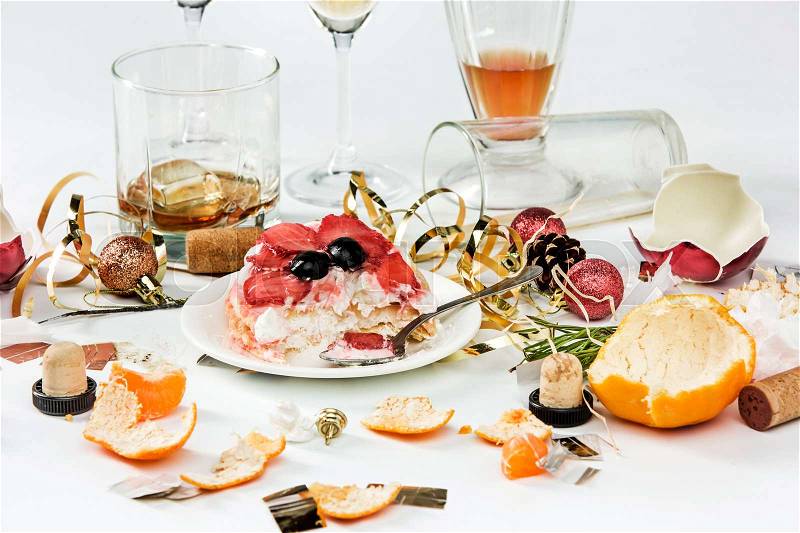 The morning after christmas day, table with alcohol and leftovers from a celebratory feast on gray, stock photo