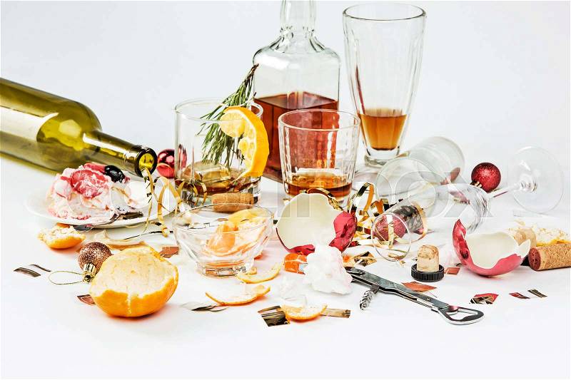 The morning after christmas day, table with alcohol and leftovers from a celebratory feast on gray, stock photo