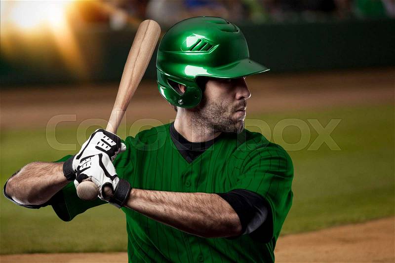 Baseball Player with a green uniform on baseball Stadium, stock photo