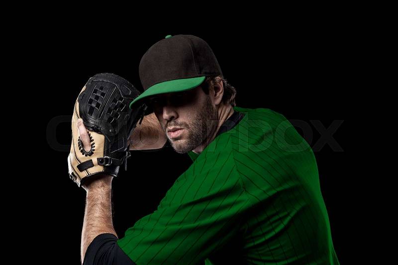 Baseball Player with a green uniform on a black background, stock photo