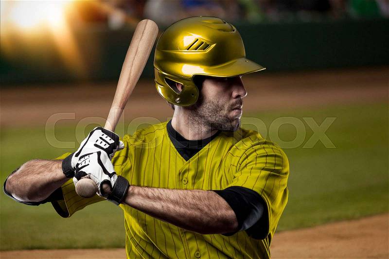 Baseball Player with a yellow uniform on baseball Stadium, stock photo