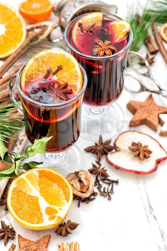 Mulled wine on white background. Hot winter cocktail with fruits and spices. Christmas table decoration, stock photo