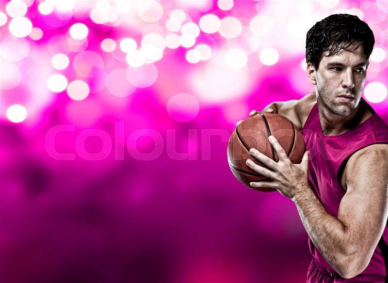 Basketball player on a pink uniform, on a pink lights background, stock photo