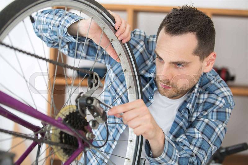 Mechanic working on gears of bicycle, stock photo