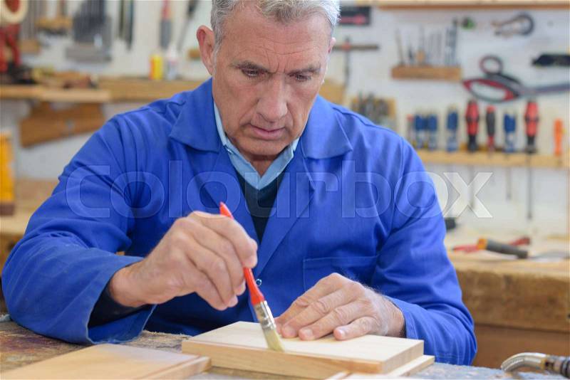 Senior man working on his work bench, stock photo