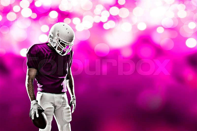 Football Player on a pink uniform, on a pink lights background, stock photo