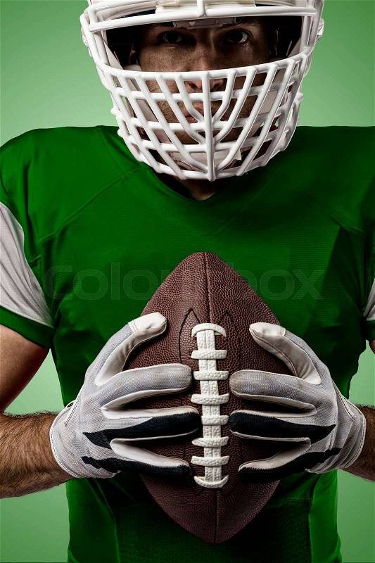 Close up of a Football Player with a green uniform on a green background, stock photo
