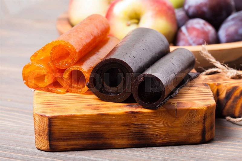 Dry fruit leather on the wooden board, plum and apple, stock photo