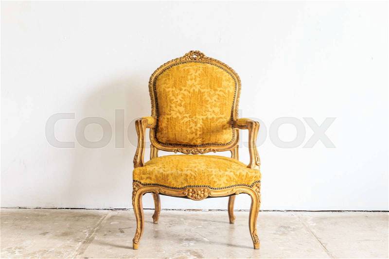 Yellow vintage armchair on white wall, stock photo
