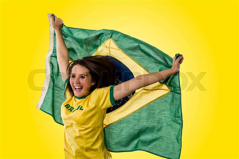 Female brazilian fan celebrating on a yellow background, stock photo