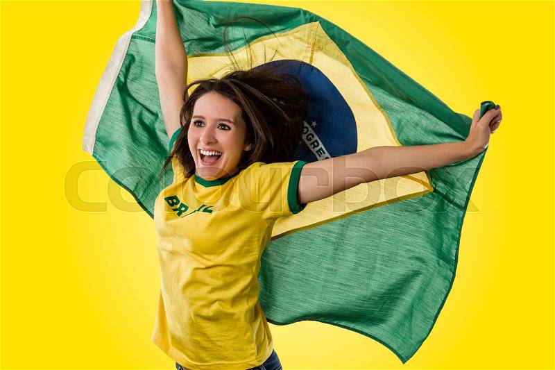 Female brazilian fan celebrating on a yellow background, stock photo
