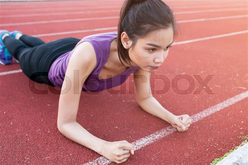 Sport urban Young athletic woman doing push-ups. Muscular and strong exercising, stock photo