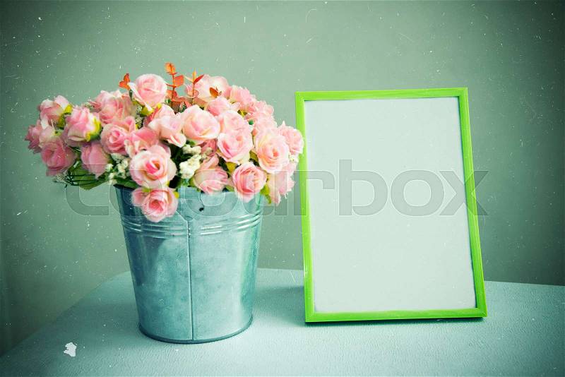 Still life of empty photo frame with rose. Vintage tone filtered. Retro scratch added. Abstract background, stock photo