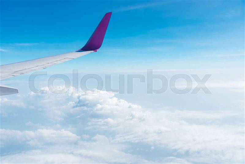 Airplane wing above the sky with cloud. Travel background, stock photo