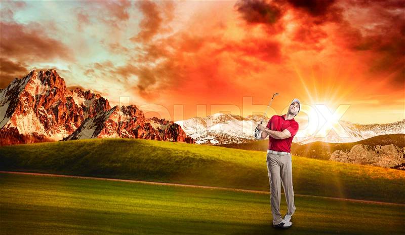 Golf Player in a red shirt taking a swing, on a golf course, stock photo