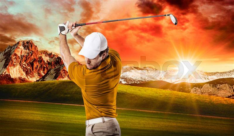 Golf Player in a orange shirt taking a swing, on a golf course, stock photo