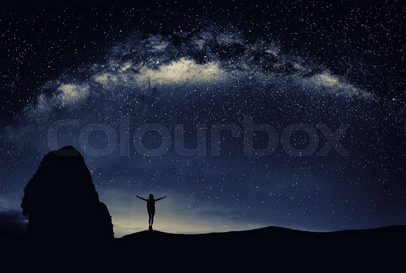 Young man standing under the stars at night. Travel concept, stock photo