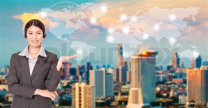 Pretty operator present world map with worldwide connection over blurry sunset city in background. Business, technology, transportation or travel background. Elements of this image furnished by NASA, stock photo