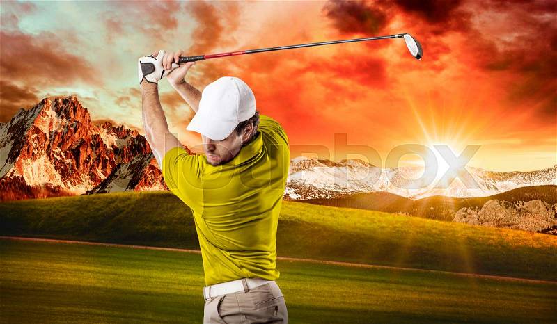 Golf Player in a yellow shirt taking a swing, on a golf course, stock photo