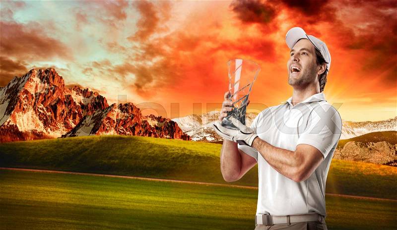 Golf Player in a white shirt celebrating with a glass trophy in his hands, on a golf course, stock photo