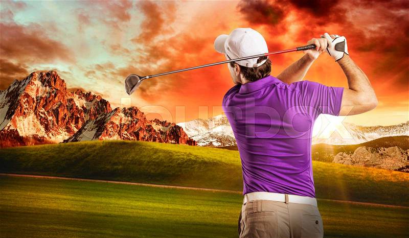 Golf Player in a purple shirt taking a swing, on a golf course, stock photo