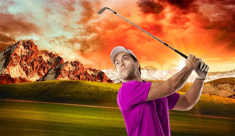 Golf Player in a pink shirt taking a swing, on a golf course, stock photo