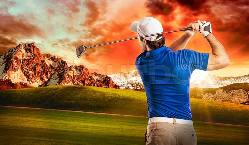 Golf Player in a blue shirt taking a swing, on a golf course, stock photo