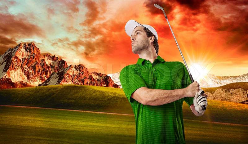 Golf Player in a green shirt taking a swing, on a golf course, stock photo