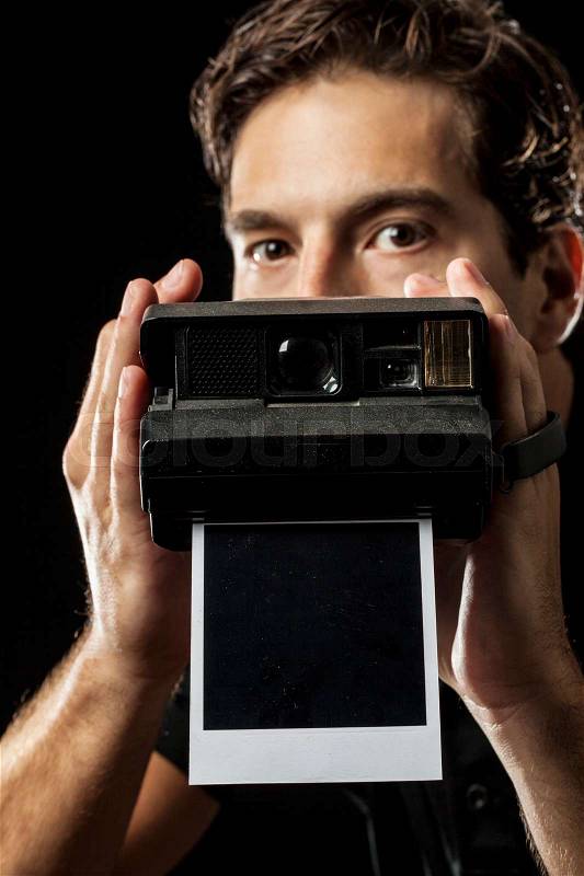 Photographer with a instant camera with a photography on black, stock photo