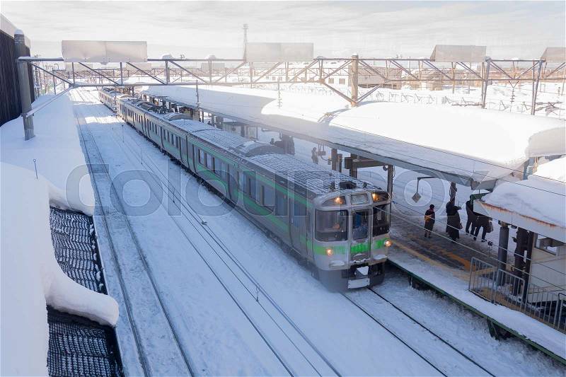 SHINSHINOTSU JANUARY 15: Train stop at railway station with snow of winter on January 15, 2016 in Shinshinotsu, Japan. Train is the important public transport rail network in Japan, stock photo