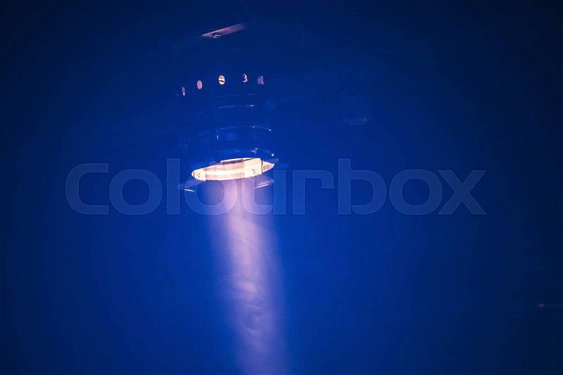 Bright scenic spot light over dark blue background, stage illumination equipment, stock photo