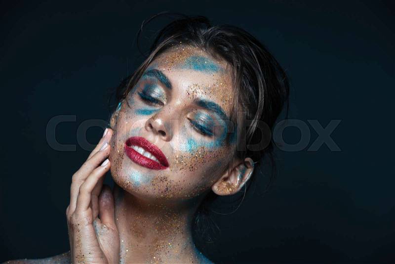 Happy young woman with blue sparkles on her face, stock photo